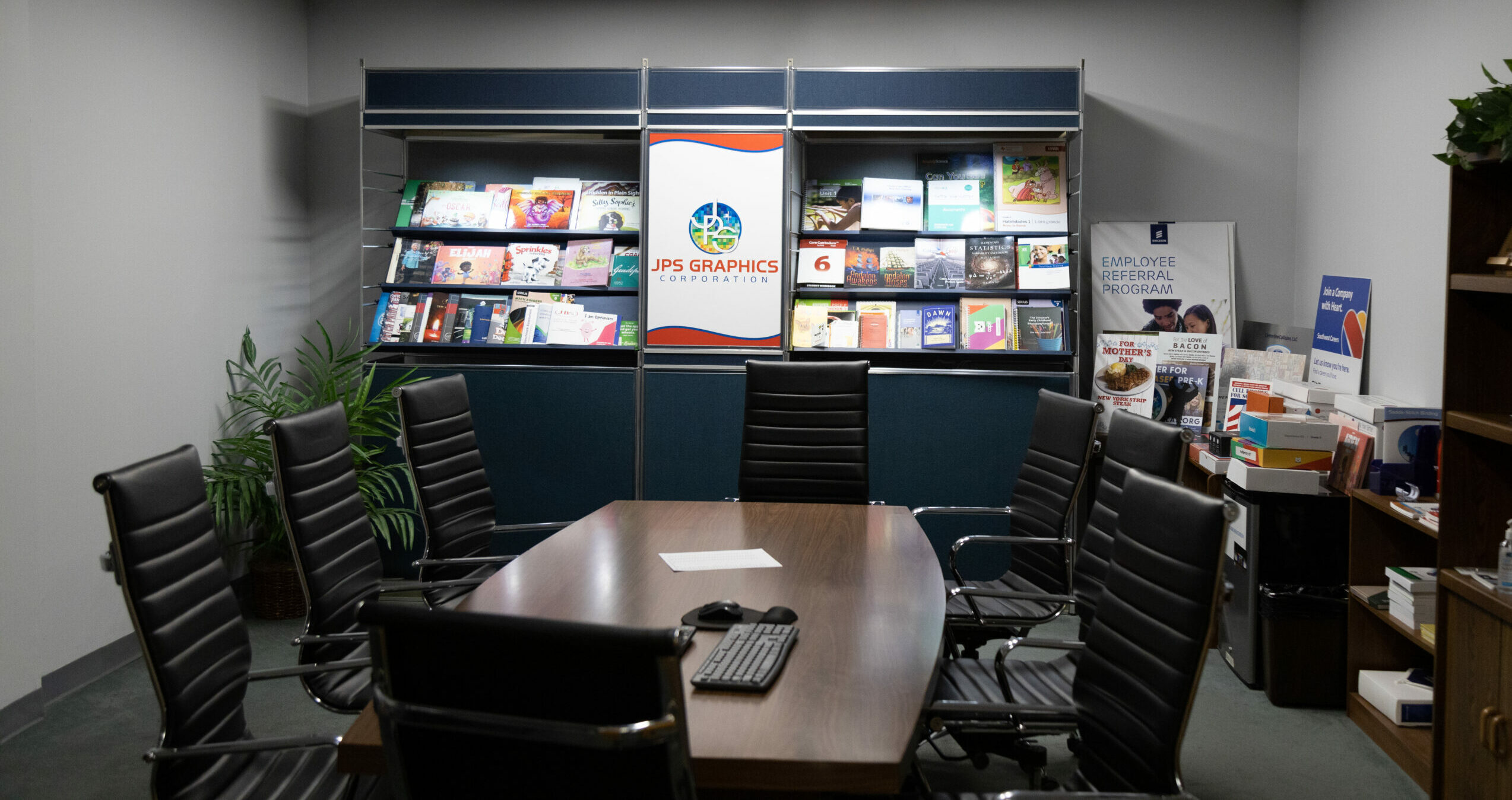 JPS Books + Logistics conference room with printed material samples, different types of bindings, hardcover vs softcover, classroom signage and printed training books